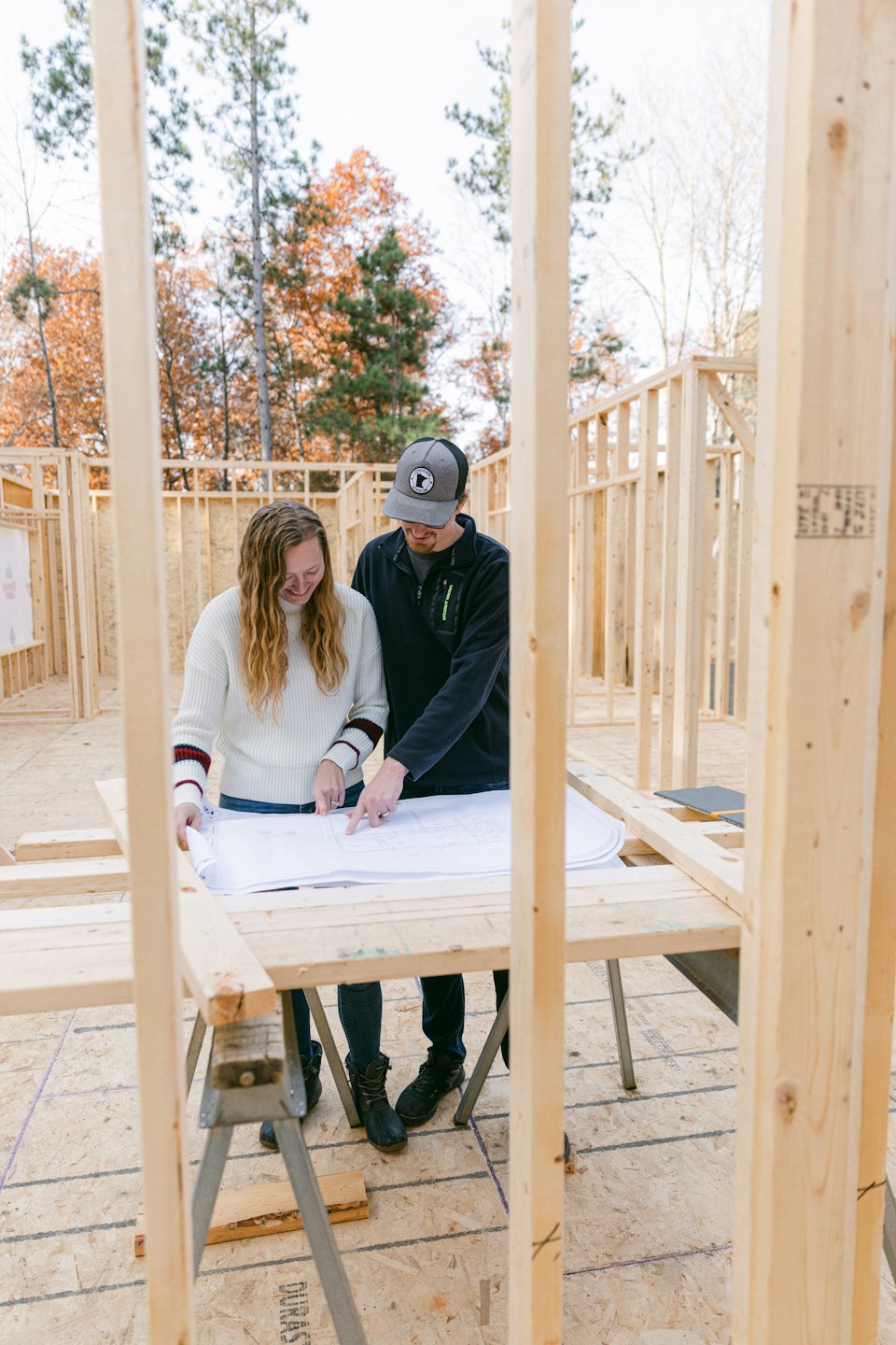 Couple reviews blueprints for new home construction.